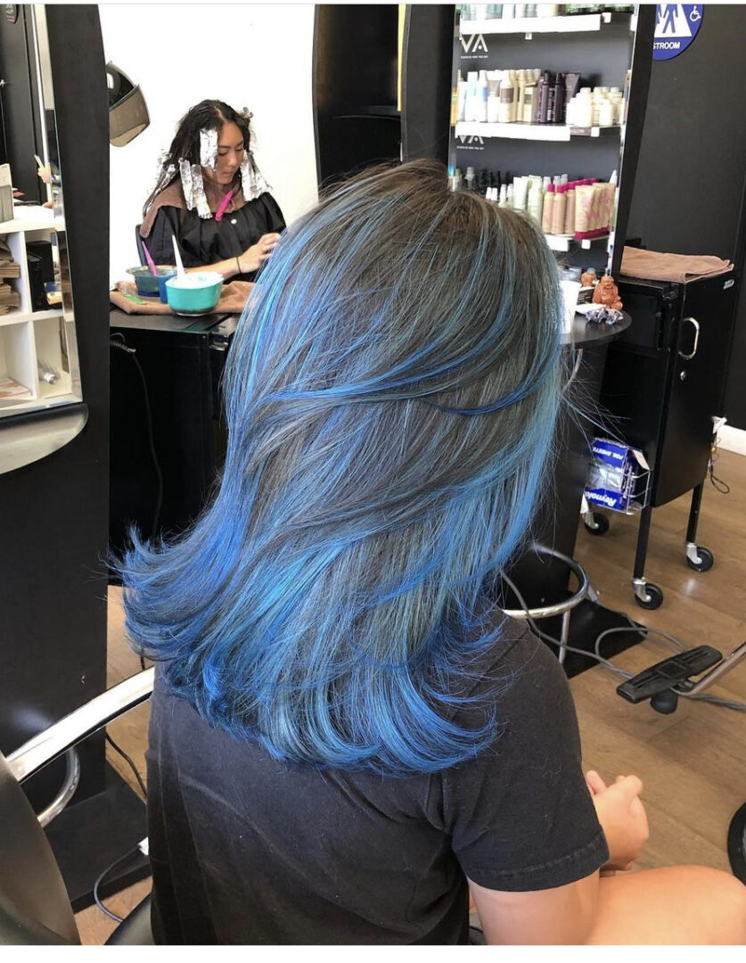 A woman with blue hair in a salon.