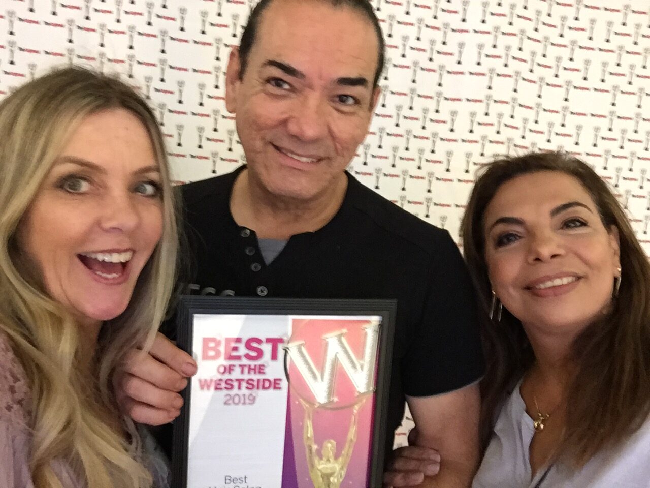 Three people holding a plaque with the words " best of westside 2 0 1 9 ".