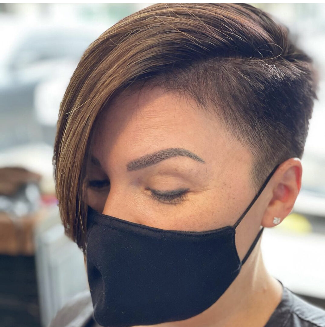 A woman with short hair and a face mask.