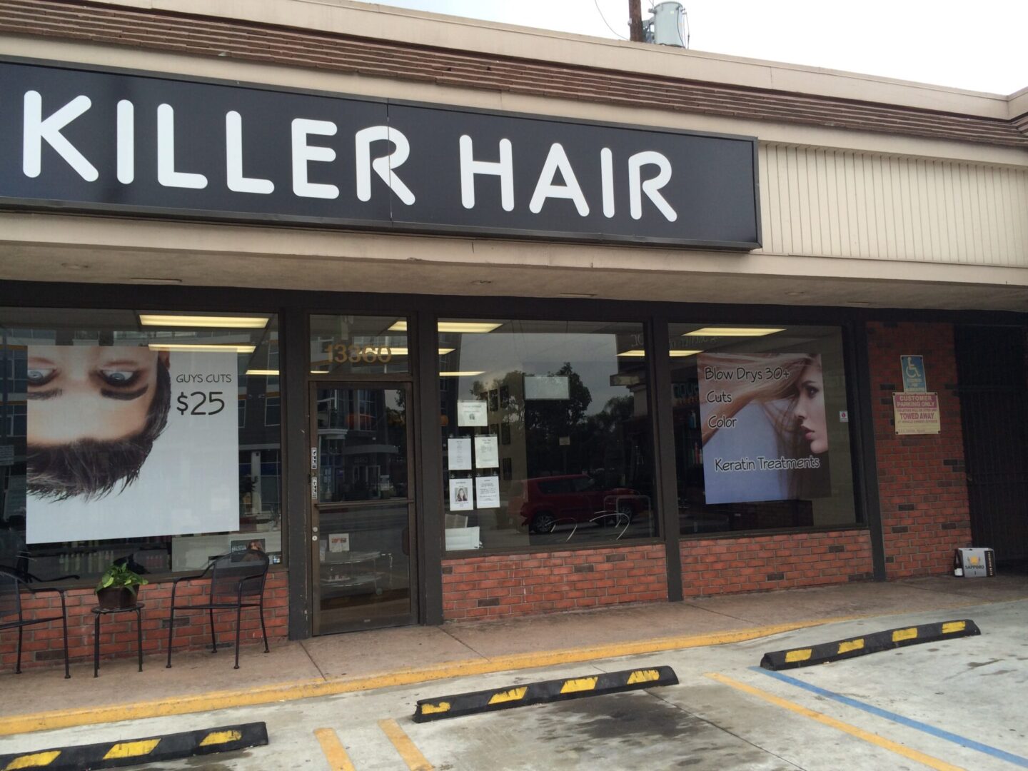 A hair salon with a lot of signage on the front.