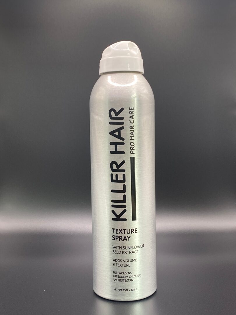 A spray bottle of hair styling product on a table.