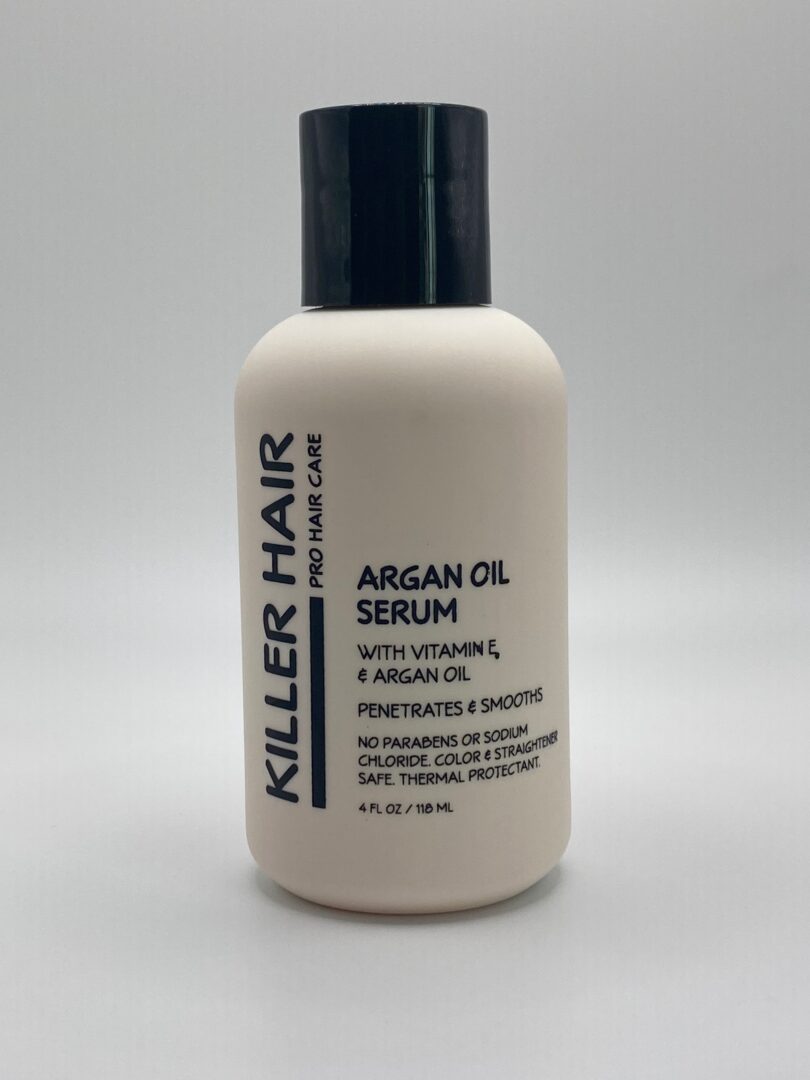 A bottle of serum with argan oil on top.